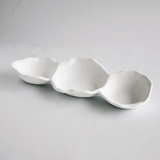 Three white ceramic bowls of varying sizes on a gray background