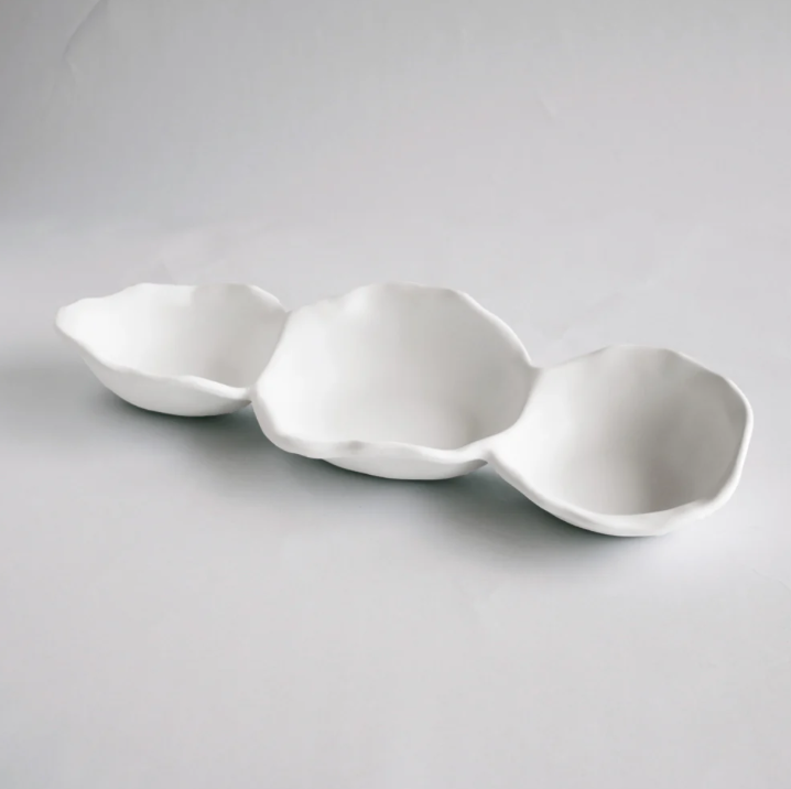 Three white ceramic bowls of varying sizes on a gray background
