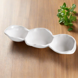 White ceramic tray with three compartments on a wooden surface