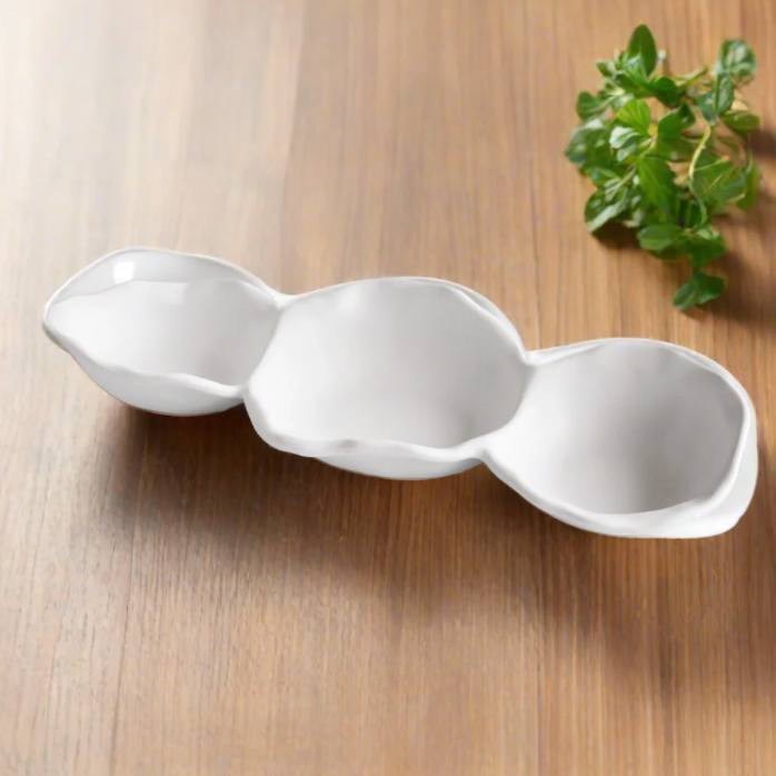 White ceramic tray with three compartments on a wooden surface