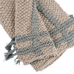 Woven blanket with a chevron pattern in beige and blue on a white background