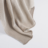Knitted beige blanket on a light gray background