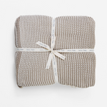 Woven blanket with a ribbon on a white background
