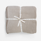 Woven blanket with a ribbon on a white background