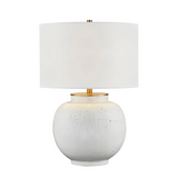 Table lamp with a white textured base and gold accents on a white background