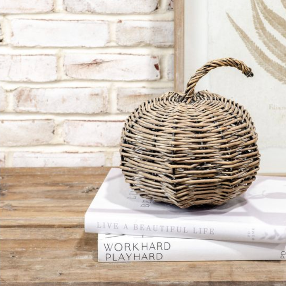 Woven pumpkin on top of books with a rustic background