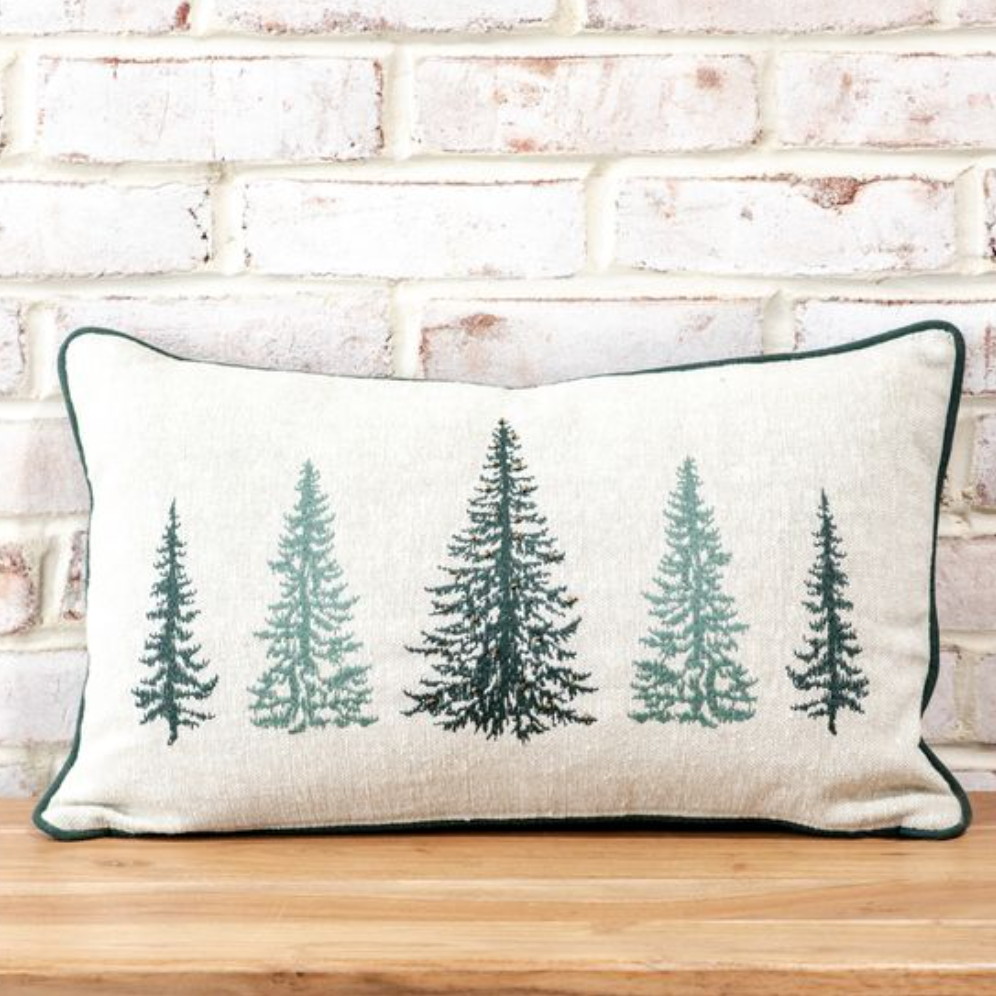 Decorative pillow with tree pattern on a wooden surface and brick wall background