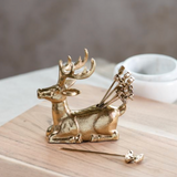 Gold deer-shaped appetizer picks and holder on a wooden surface