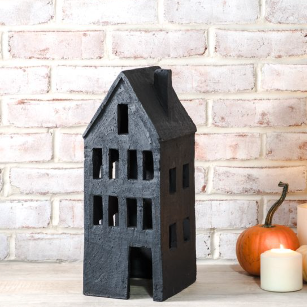 Black Terracotta house with a white brick wall background
