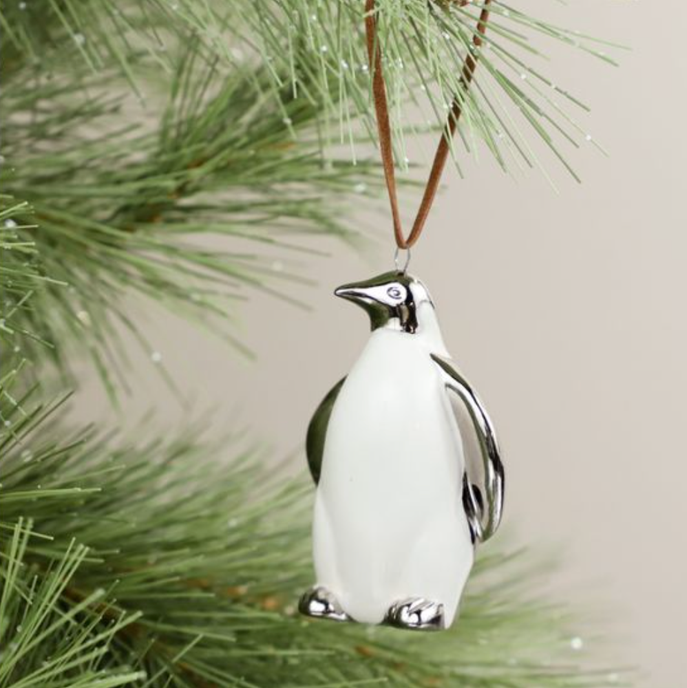 Penguin ornament hanging on a Christmas tree branch
