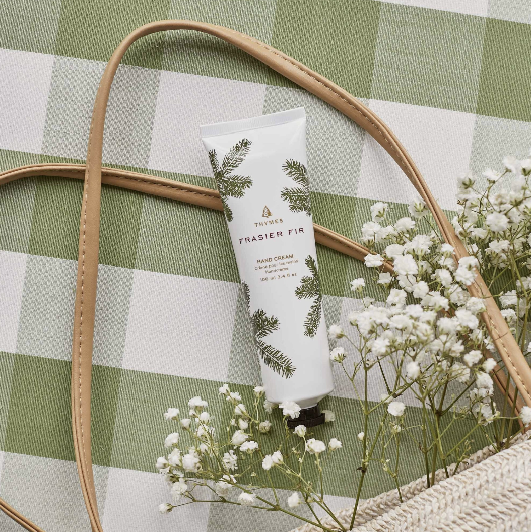 Hand cream tube with greenery design on a checkered fabric background