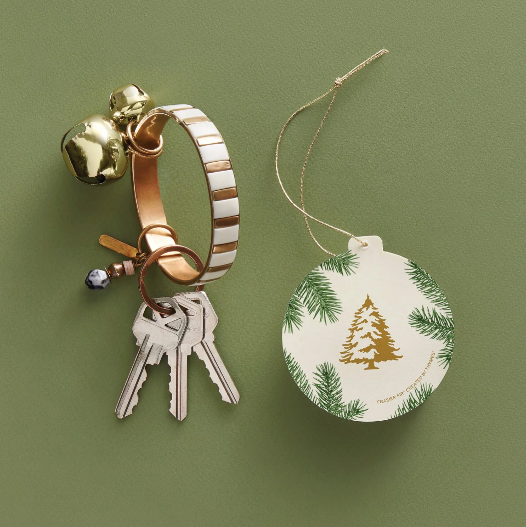 Keychain with bell and keys next to a Christmas ornament on a green background