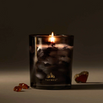 Thymes candle in a dark glass container with a blurred background