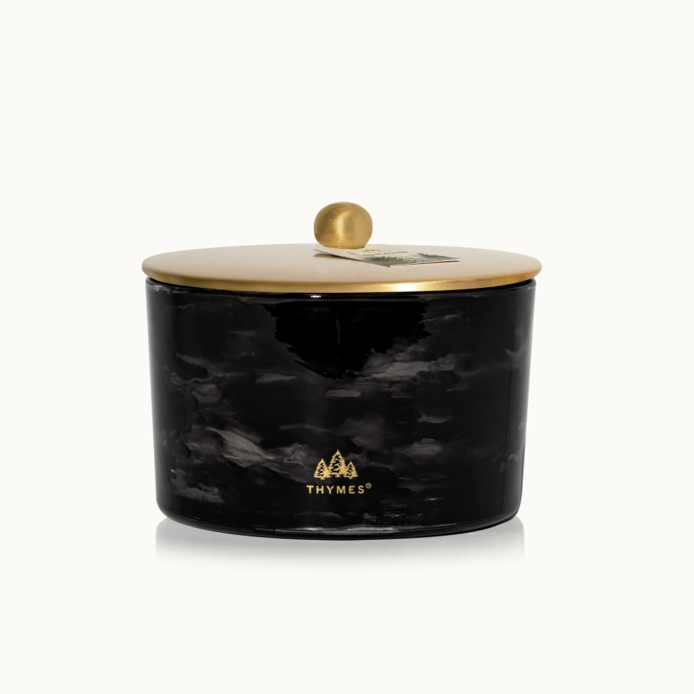 Black marbled candle jar with gold lid on a white background, featuring the Thymes logo.