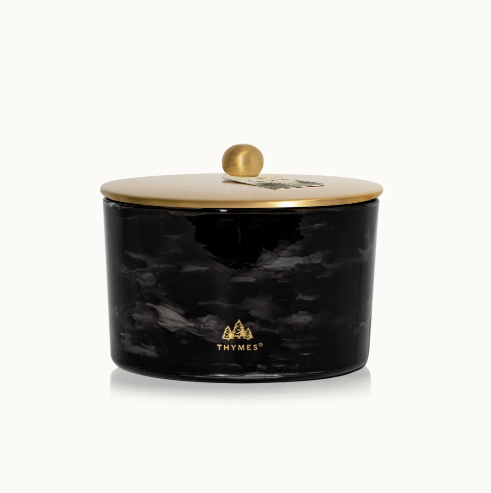 Black marbled candle jar with gold lid on a white background, featuring the Thymes logo.