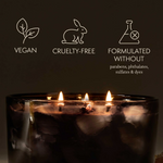 Candle with vegan, cruelty-free, and sulfate-free icons on a dark background