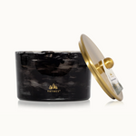 Black marbled candle with a gold lid on a white background, featuring the Thymes logo.