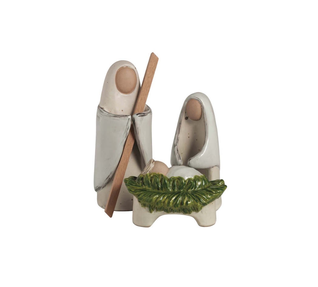 Decorative ceramic nativity scene with two figures and a baby in a manger on a white background.
