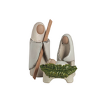 Decorative ceramic nativity scene with two figures and a baby in a manger on a white background.