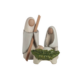 Decorative ceramic nativity scene with two figures and a baby in a manger on a white background.