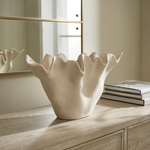 styled sculptural sand-textured ceramic bowl on a wooden surface with a neutral background