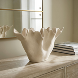 styled sculptural sand-textured ceramic bowl on a wooden surface with a neutral background