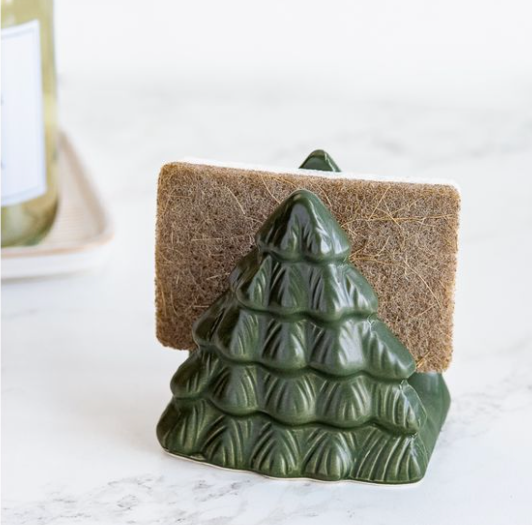 Green ceramic tree-shaped holder with a sponge on a white surface