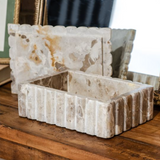 Open marble box showing interior and matching scalloped lid, featuring natural veining and ribbed exterior, styled on a wooden surface.