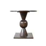 Bronze-colored round table with a unique base design on a white background