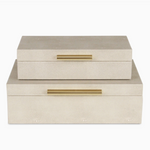 Two beige jewelry boxes with gold handles on a white background