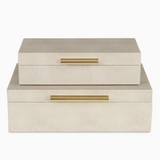 Two beige jewelry boxes with gold handles on a white background