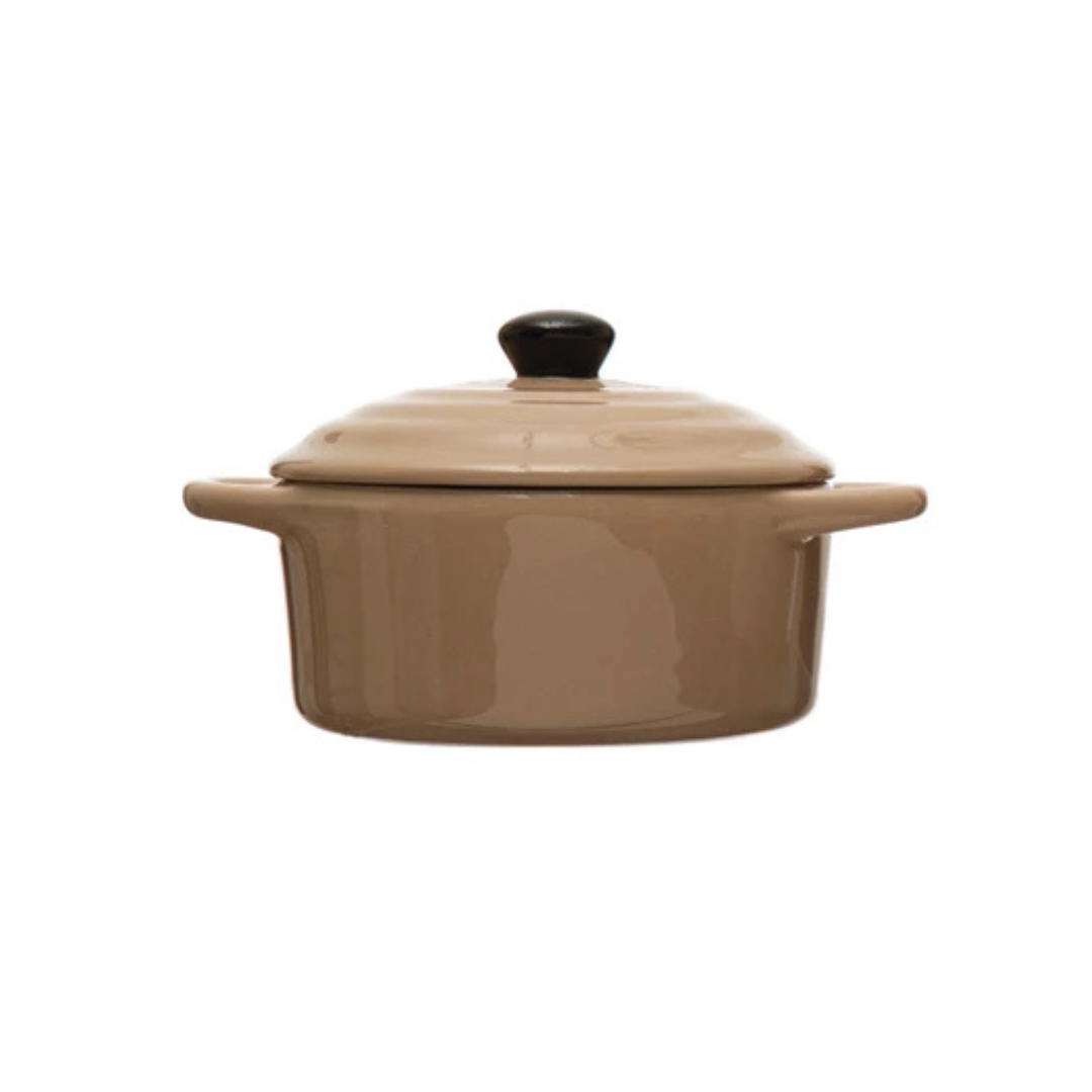 Brown ceramic cooking pot with a black lid knob on a white background