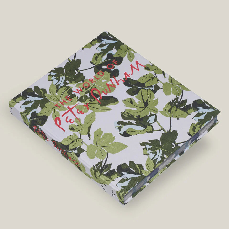 Book with green leaf pattern and red text on a beige background