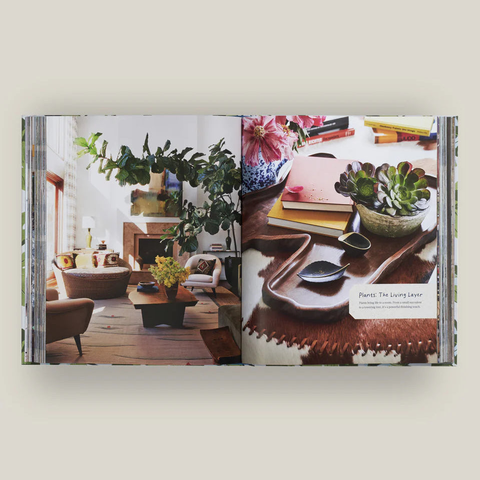 Open book showing interior design images of a living room and table setting.