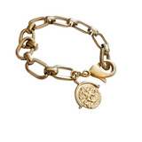 Bracelet features elongated gold oval links and a bold coin charm embossed with a regal horse.