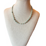 Necklace on a mannequin bust with a plain background