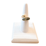 Gold ring with a stone on a white marble stand