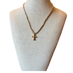 Necklace with a cross pendant on a mannequin bust against a white background