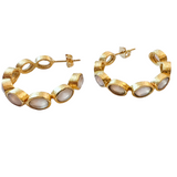 Gold hoop earrings with circular designs on a white background