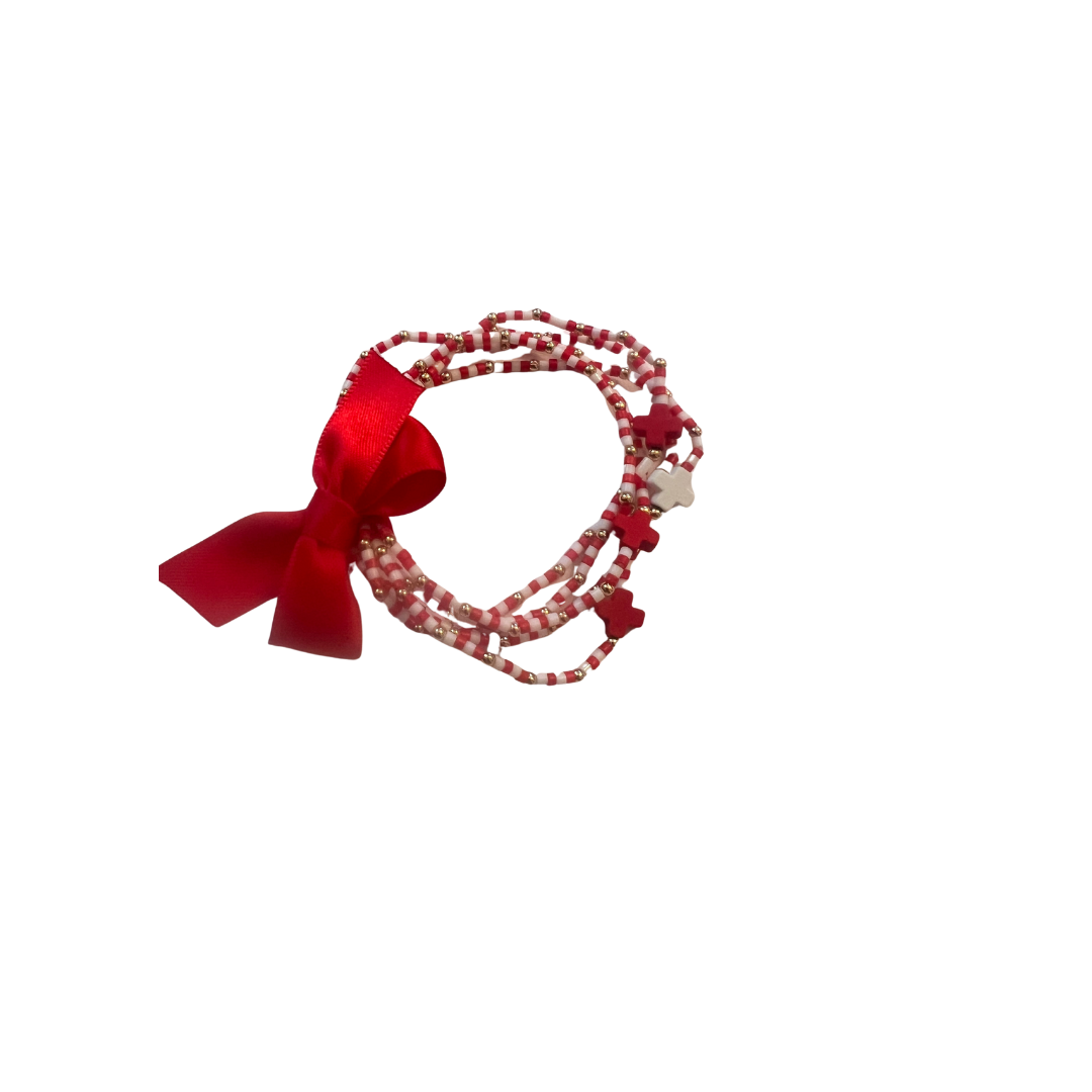 Red bow and beaded bracelet on a white background