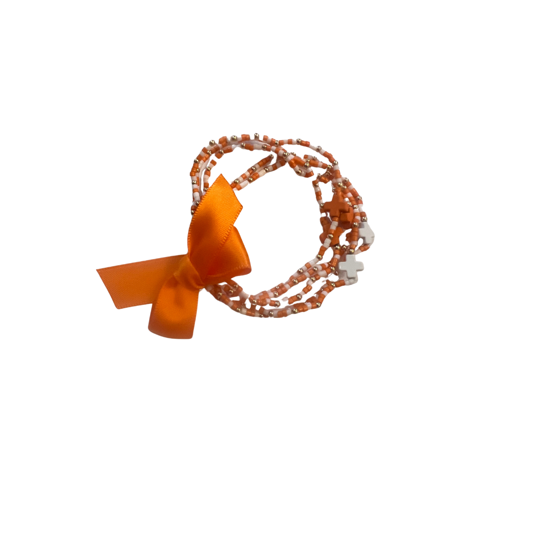 Orange beaded bracelet with a bow on a white background
