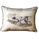 Decorative pillow with a checkered border featuring an illustration of a dog in a natural setting.