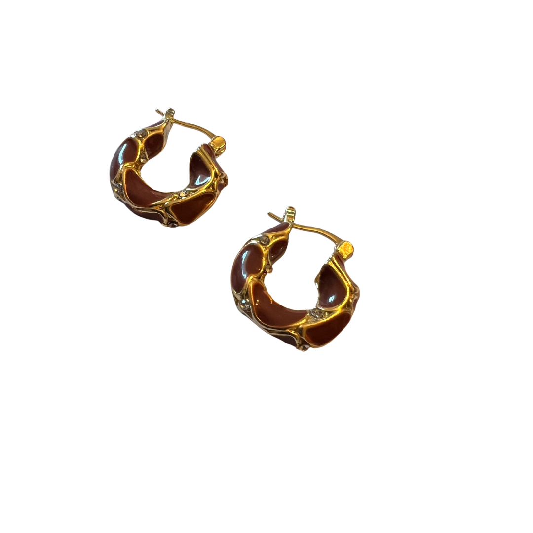 Pair of gold hoop earrings with brown enameled design on a white background