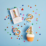Sprinkled wax number candle on plastic stake.