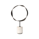Decorative object with circular metal top and marble base on a white background