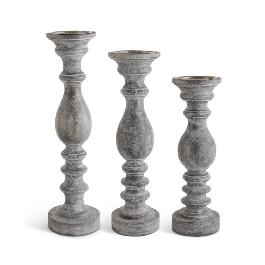 Three gray candle holders of different heights on a white background