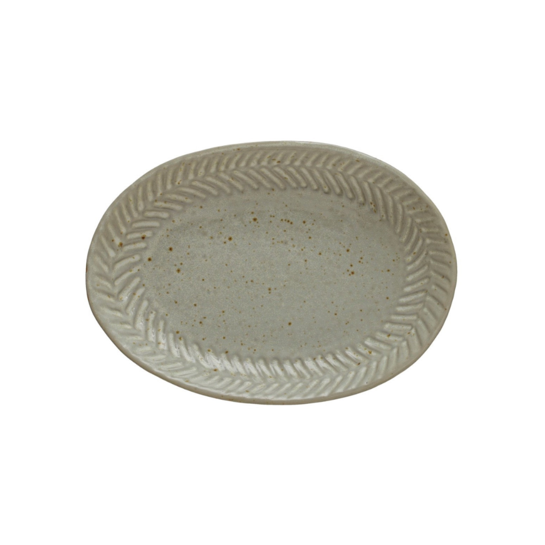 Round ceramic plate with wavy edge design on a white background