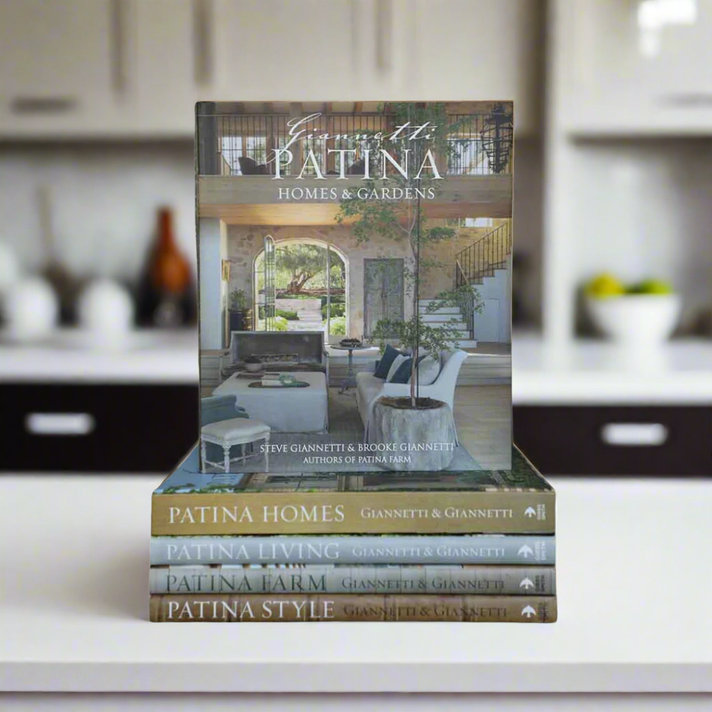Stack of books titled 'Patina Homes & Gardens' on a white background