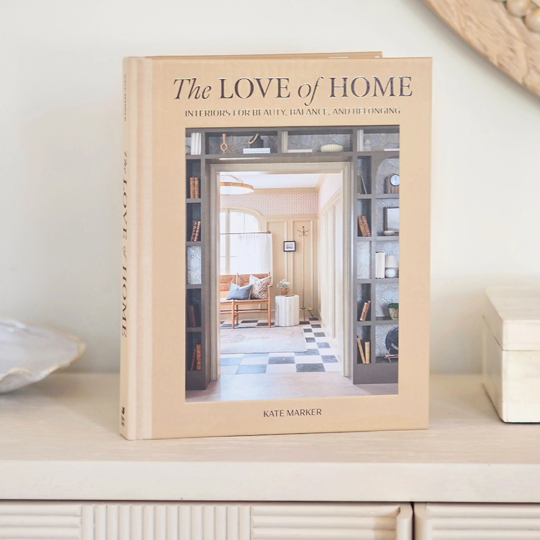 Book titled 'The Love of Home' by Kate Marker on a shelf with a neutral background
