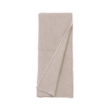 Folded beige knitted blanket on a white background